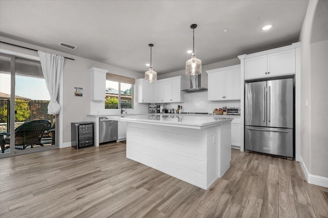 2653 Vermont Ave, Clovis, CA 93619 - kitchen with appliances with stainless steel finishes, wall chimney exhaust hood, beverage cooler, light wood-style flooring, and recessed lighting