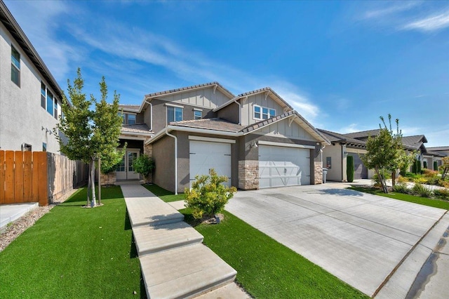 2653 Vermont Ave, Clovis, CA 93619 - view of front of property featuring board and batten siding, stone siding, driveway, a tiled roof, and a garage