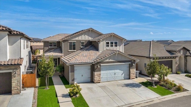 2653 Vermont Ave, Clovis, CA 93619 - view of front of property featuring board and batten siding, driveway, a garage, stone siding, and fence