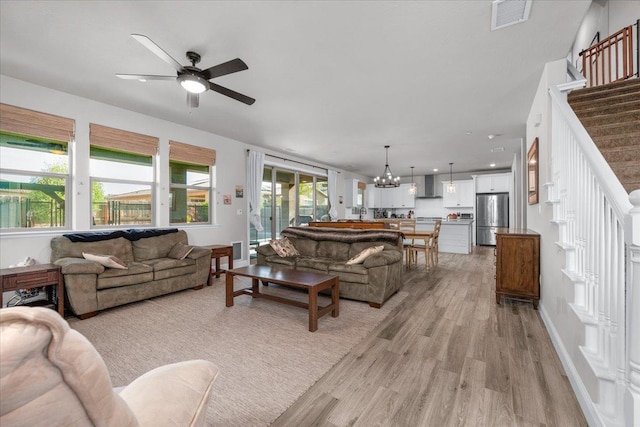 2653 Vermont Ave, Clovis, CA 93619 - living room featuring light wood-type flooring, stairs, ceiling fan, a chandelier, and baseboards