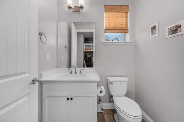 2653 Vermont Ave, Clovis, CA 93619 - half bath featuring toilet, baseboards, vanity, and wood finished floors
