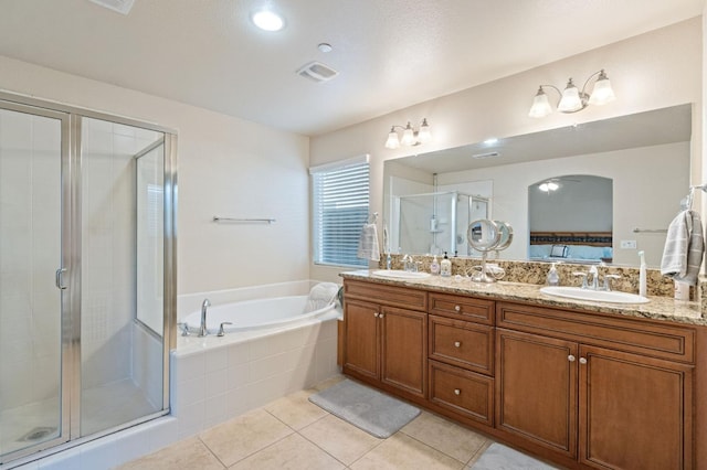 bathroom featuring a garden tub, tile patterned floors, a stall shower, and a sink