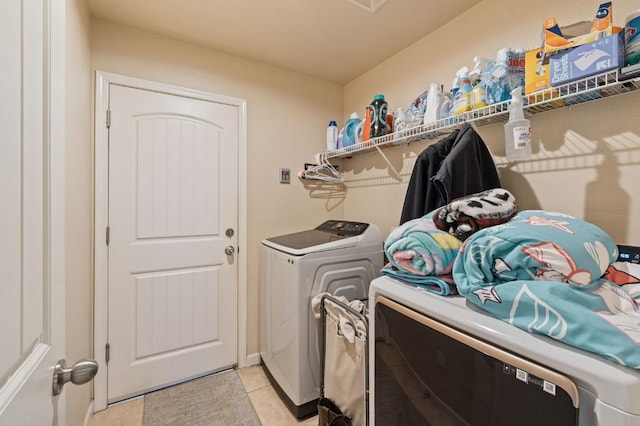 laundry room with separate washer and dryer, laundry area, and light tile patterned floors