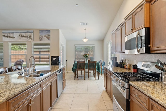 kitchen featuring stainless steel appliances, a sink, visible vents, brown cabinetry, and light tile patterned floors