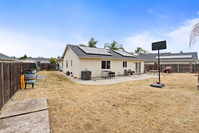 3617 Clay Ct, Selma, CA 93662 - back of house with central AC unit, a fenced backyard, a yard, stucco siding, and solar panels