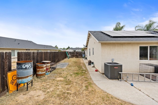 3617 Clay Ct, Selma, CA 93662 - view of side of home featuring central AC, a lawn, a fenced backyard, roof mounted solar panels, and stucco siding