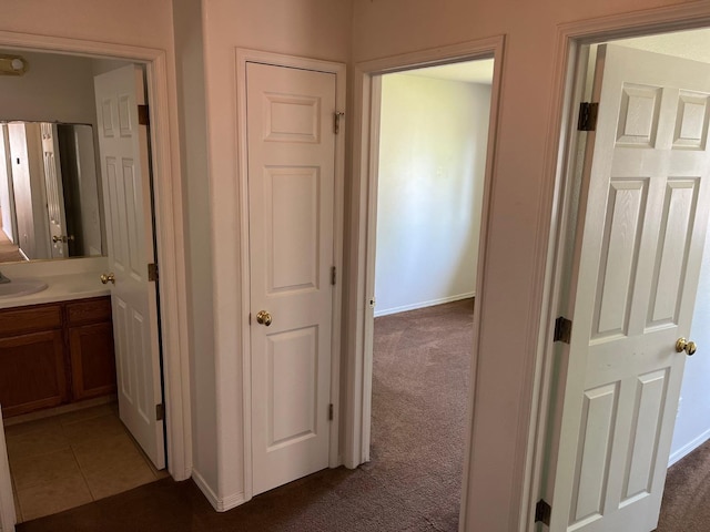 1836 Heidi Ave, Sanger, CA 93657 - corridor with light colored carpet, baseboards, a sink, and light tile patterned floors