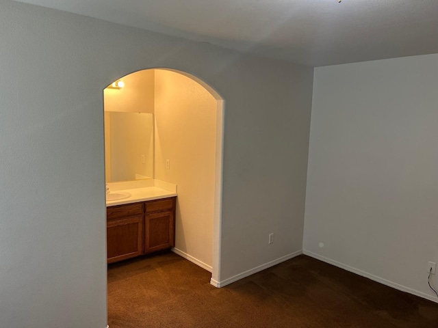 1836 Heidi Ave, Sanger, CA 93657 - spare room featuring arched walkways, dark carpet, baseboards, and a sink