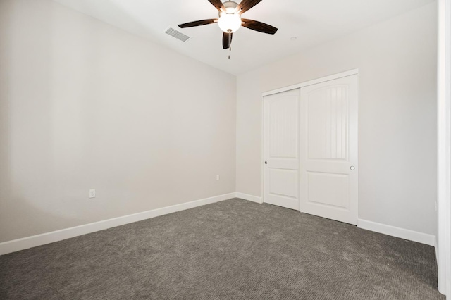 11182 N Via Ravenna Dr, Fresno, CA 93730 - unfurnished bedroom with dark carpet, visible vents, a closet, baseboards, and ceiling fan