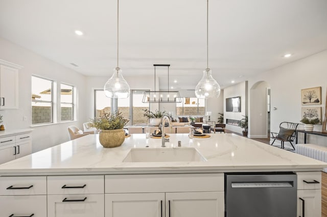 11182 N Via Ravenna Dr, Fresno, CA 93730 - kitchen with white cabinets, stainless steel dishwasher, a sink, arched walkways, and a center island with sink