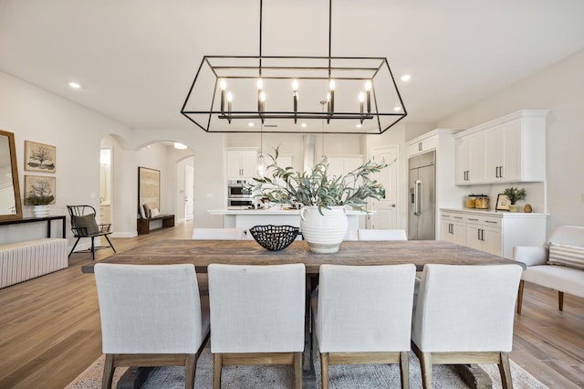 11182 N Via Ravenna Dr, Fresno, CA 93730 - dining area with arched walkways, radiator heating unit, light wood-style flooring, and recessed lighting