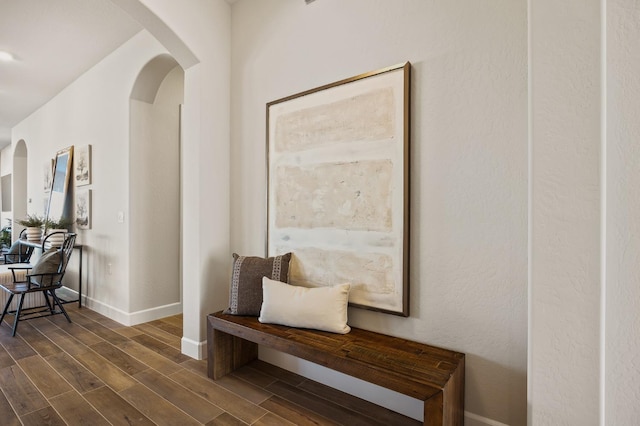11182 N Via Ravenna Dr, Fresno, CA 93730 - hall featuring arched walkways, dark wood-type flooring, and baseboards