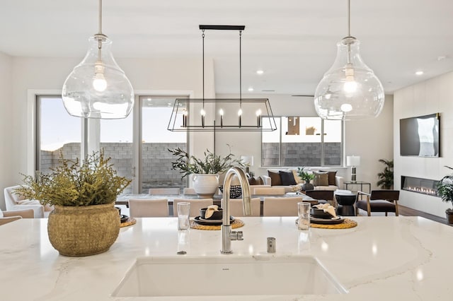 11182 N Via Ravenna Dr, Fresno, CA 93730 - kitchen featuring open floor plan, a chandelier, pendant lighting, and a sink