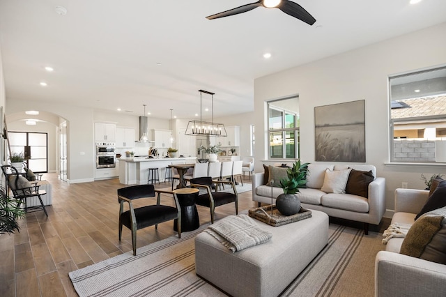 11182 N Via Ravenna Dr, Fresno, CA 93730 - living area featuring wood finished floors, arched walkways, recessed lighting, and ceiling fan