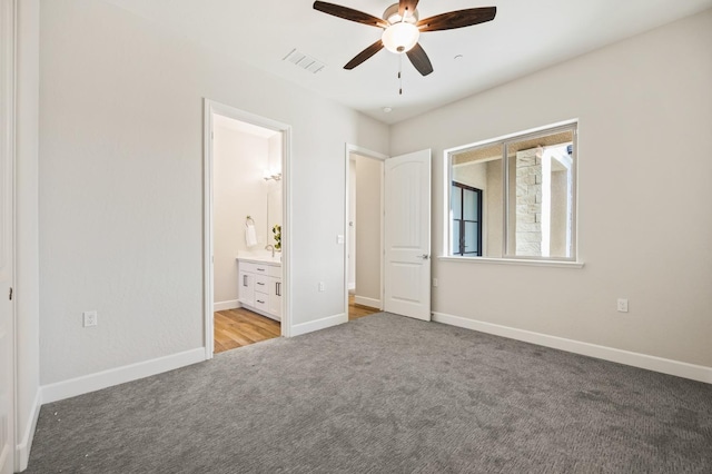 11182 N Via Ravenna Dr, Fresno, CA 93730 - unfurnished bedroom with a ceiling fan, connected bathroom, light carpet, baseboards, and visible vents