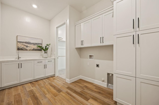 11182 N Via Ravenna Dr, Fresno, CA 93730 - clothes washing area with hookup for an electric dryer, baseboards, light wood-style floors, hookup for a washing machine, and cabinet space