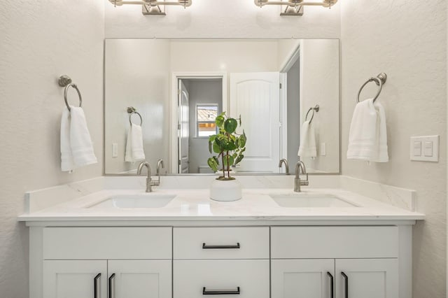 11182 N Via Ravenna Dr, Fresno, CA 93730 - full bathroom featuring a textured wall, a sink, and double vanity