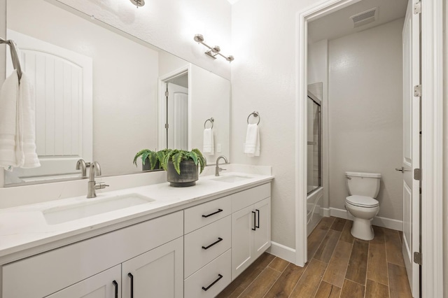 11182 N Via Ravenna Dr, Fresno, CA 93730 - full bath featuring double vanity, wood finished floors, visible vents, and a sink