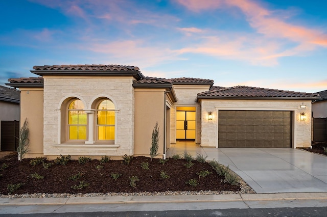 11182 N Via Ravenna Dr, Fresno, CA 93730 - mediterranean / spanish-style home with a tile roof, driveway, stone siding, an attached garage, and stucco siding