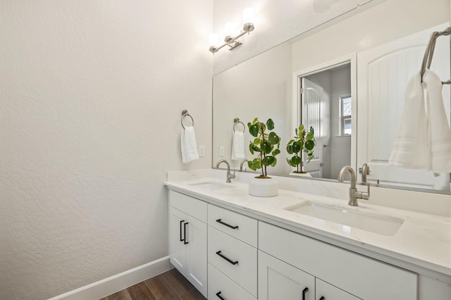 11182 N Via Ravenna Dr, Fresno, CA 93730 - full bathroom featuring baseboards, wood finished floors, a sink, and double vanity