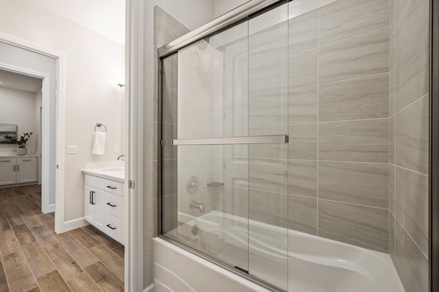 11182 N Via Ravenna Dr, Fresno, CA 93730 - bathroom featuring baseboards, vanity, wood tiled floor, and bath / shower combo with glass door