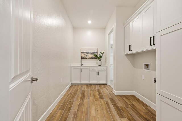 11182 N Via Ravenna Dr, Fresno, CA 93730 - washroom featuring electric dryer hookup, cabinet space, light wood-style floors, and washer hookup
