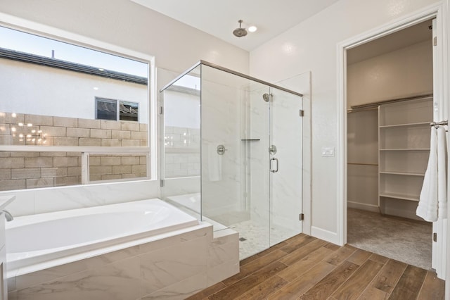 11182 N Via Ravenna Dr, Fresno, CA 93730 - bathroom with a shower stall, a bath, a walk in closet, and wood finished floors