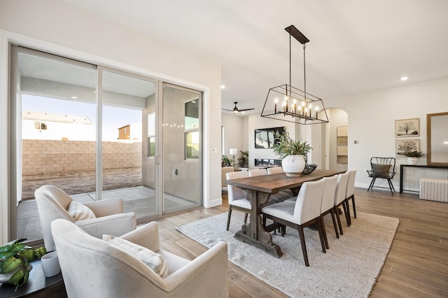 11182 N Via Ravenna Dr, Fresno, CA 93730 - dining area featuring light wood-type flooring, ceiling fan, arched walkways, radiator, and recessed lighting