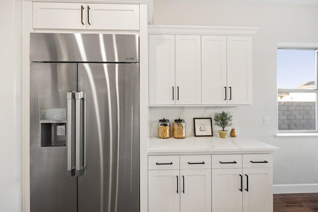 11182 N Via Ravenna Dr, Fresno, CA 93730 - kitchen featuring dark wood-type flooring, light stone countertops, baseboards, stainless steel fridge, and white cabinetry