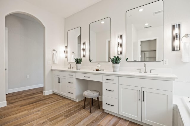 11182 N Via Ravenna Dr, Fresno, CA 93730 - full bath with baseboards, wood finished floors, a sink, and double vanity