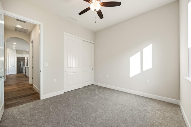 11182 N Via Ravenna Dr, Fresno, CA 93730 - unfurnished bedroom featuring arched walkways, baseboards, visible vents, carpet, and a closet