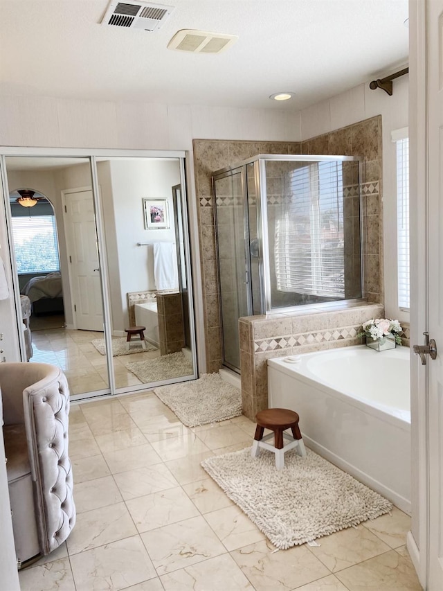 ensuite bathroom featuring visible vents, marble finish floor, a shower stall, a garden tub, and ensuite bath
