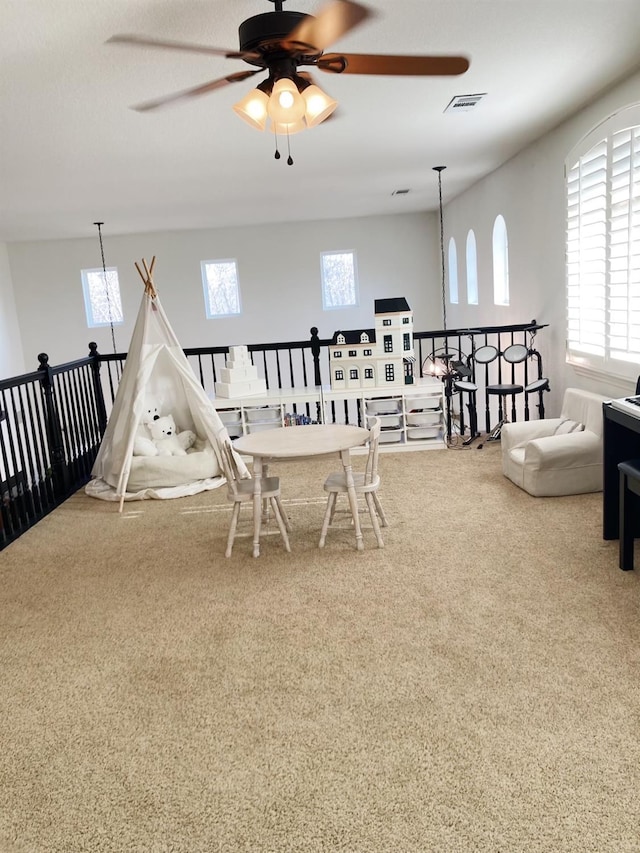 playroom with carpet floors, a ceiling fan, and visible vents
