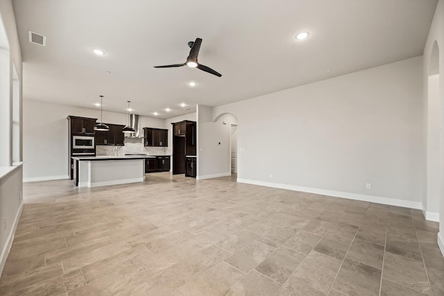 6294 E Miillie Dr, Fresno, CA 93727 - unfurnished living room featuring ceiling fan, arched walkways, visible vents, and recessed lighting