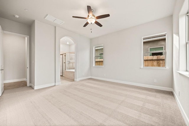 6294 E Miillie Dr, Fresno, CA 93727 - unfurnished bedroom with light colored carpet, arched walkways, ensuite bathroom, and baseboards