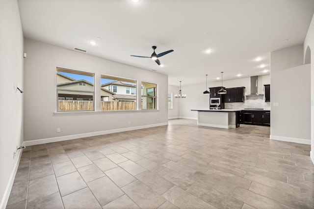 6294 E Miillie Dr, Fresno, CA 93727 - unfurnished living room featuring ceiling fan with notable chandelier, baseboards, visible vents, and recessed lighting