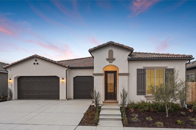 6294 E Miillie Dr, Fresno, CA 93727 - mediterranean / spanish house with stucco siding, a tile roof, driveway, and a garage