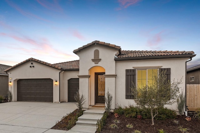 6294 E Miillie Dr, Fresno, CA 93727 - mediterranean / spanish-style home featuring an attached garage, a tiled roof, stucco siding, and driveway