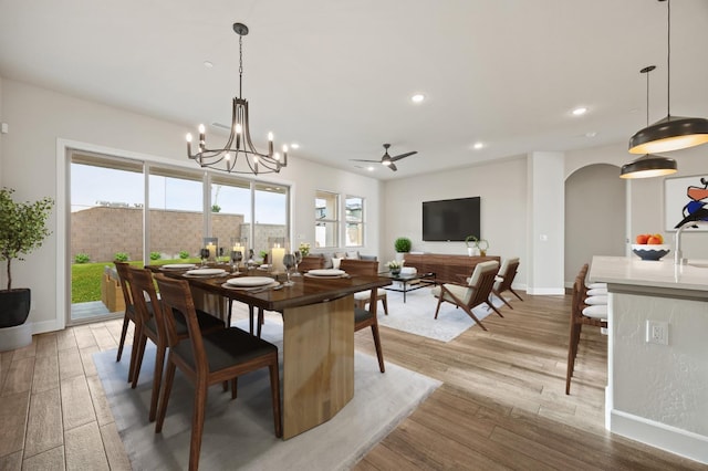dining room with arched walkways, ceiling fan with notable chandelier, baseboards, and recessed lighting