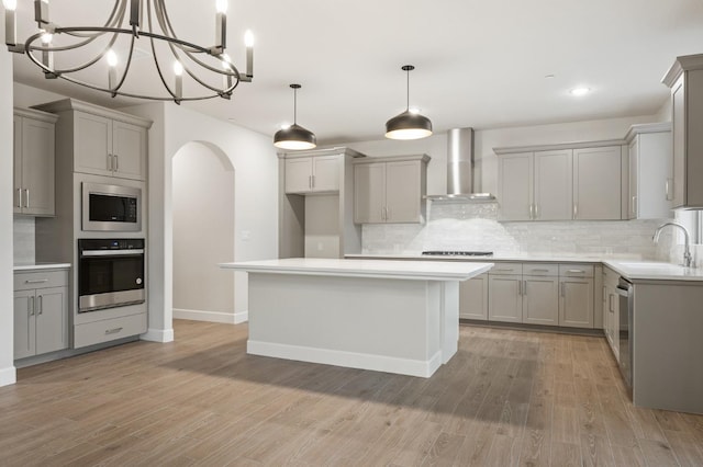 4288 N Phoenix, Fresno, CA 93723 - kitchen with wall chimney range hood, appliances with stainless steel finishes, gray cabinetry, arched walkways, and recessed lighting