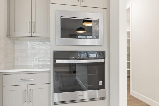 room details featuring stainless steel appliances, light countertops, baseboards, and tasteful backsplash