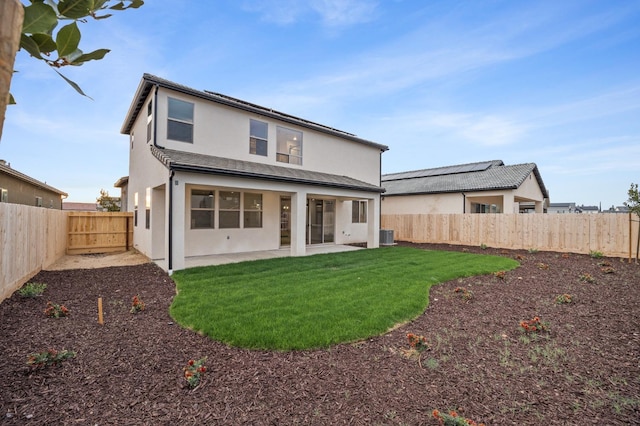 rear view of property with a patio area, a lawn, a fenced backyard, and stucco siding