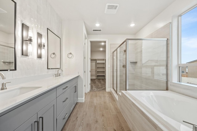 bathroom featuring a shower stall, visible vents, a wealth of natural light, and a sink