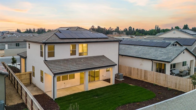 4288 N Phoenix, Fresno, CA 93723 - rear view of house featuring stucco siding, a fenced backyard, roof mounted solar panels, and a patio