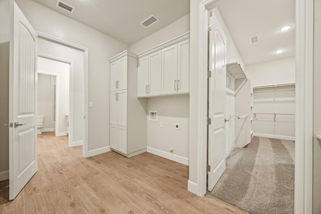 laundry room with electric dryer hookup, hookup for a washing machine, visible vents, and baseboards