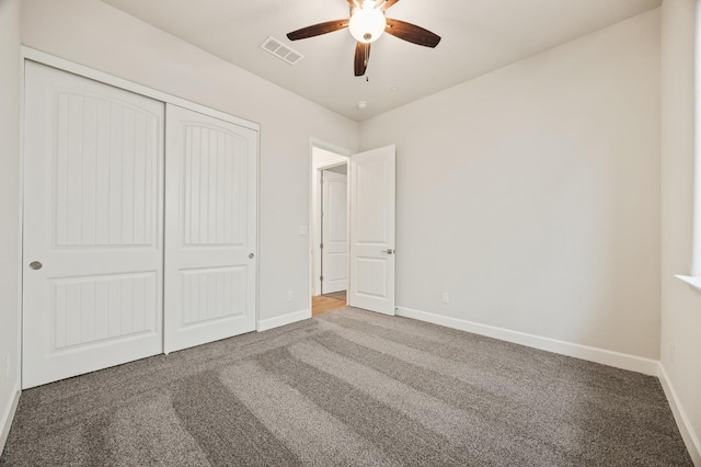 unfurnished bedroom featuring a closet, ceiling fan, carpet, baseboards, and visible vents