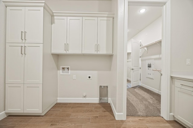 laundry room featuring hookup for an electric dryer, cabinet space, light wood-style flooring, baseboards, and washer hookup