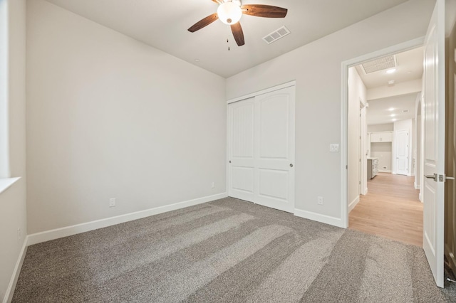 unfurnished bedroom with a closet, carpet floors, visible vents, and baseboards