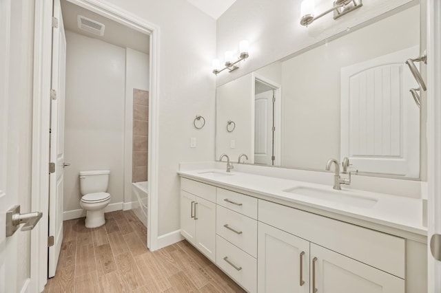 full bath with wood finished floors, visible vents, a sink, and toilet