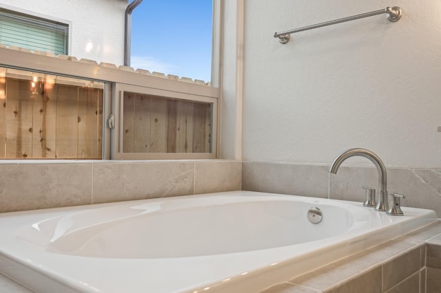 bathroom with a bath and a textured wall